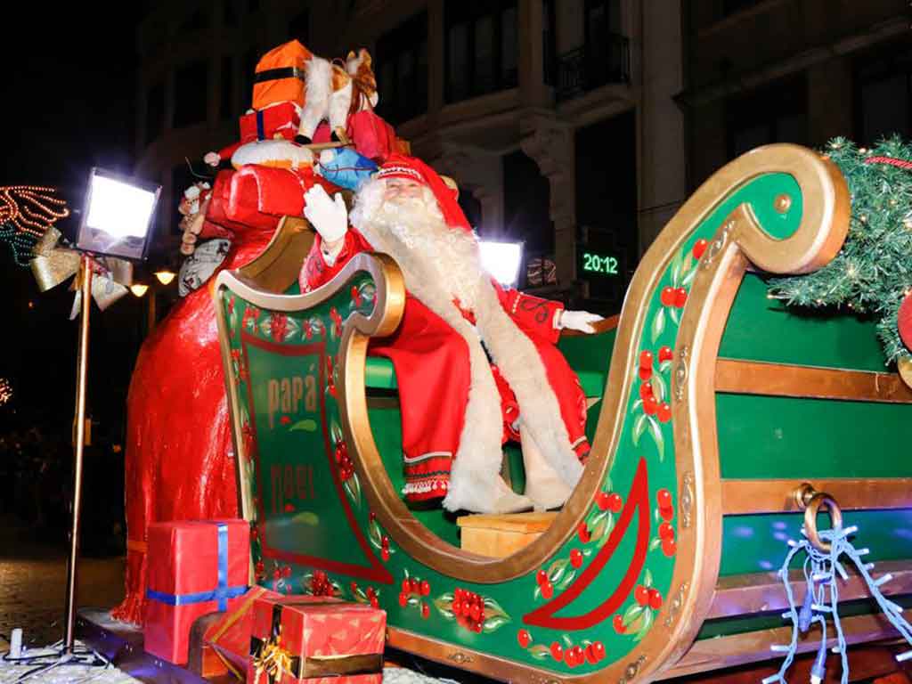 Papá Noel saluda desde un enorme trineo en una carroza de la Cabalgaza